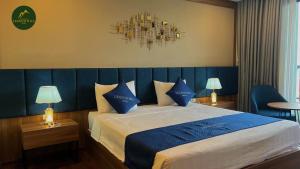 a bedroom with a large bed with blue pillows at Thái Nguyên Legend Hill 
