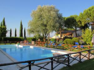 マルシャーノにあるFarmhouse in Marsciano with vineyards olive grovesの椅子と木々のある庭のスイミングプール