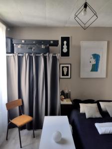 a living room with a bed and a couch and a table at Studio moderne, propre et calme in Melun