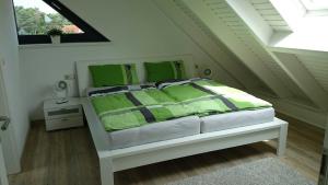Un dormitorio con una cama con almohadas verdes y una ventana en Ferienhaus Luise Urlaubslust Trassenheide en Trassenheide