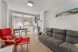 Il comprend un salon avec un canapé et une cuisine. dans l'établissement Ruime woning 10p met zonnige tuin & nabij strand, à Blankenberge