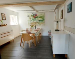 Hochwertiges Fischerhus mit Terrasse und Grill في غرايفسفالد: مطبخ وغرفة طعام مع طاولة وكراسي