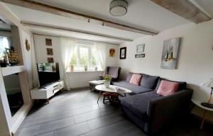 ein Wohnzimmer mit einem Sofa und einem Tisch in der Unterkunft Hochwertiges Fischerhus mit Terrasse und Grill in Greifswald
