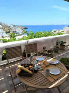 stół z jedzeniem na balkonie w obiekcie Primrose Apartments w mieście Astypalea