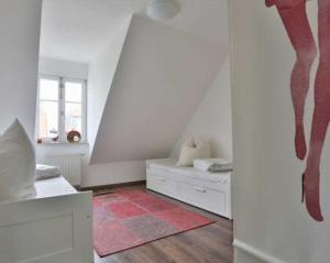 a bedroom with two beds and a red rug at Hochwertige Ferienwohnung direkt am Wasser mit Balkon in Greifswald