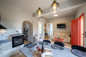 a kitchen and living room with a table and chairs at Agapanthus Retreat in Kouvaláta
