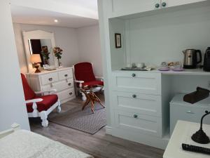 um quarto com uma cómoda branca e uma cadeira vermelha em Casa d'Artengo em Ponte de Lima