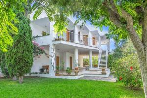 an exterior view of a white house with trees at Palma bay views 20m from the sea in Bellavista