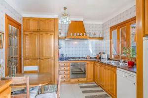 a kitchen with wooden cabinets and a wooden table at Palma bay views 20m from the sea in Bellavista