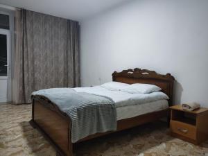 a bedroom with a large bed with a wooden headboard at Hotel Talin in Talin