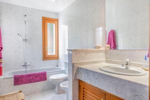 a bathroom with a sink and a tub and a toilet at Palma bay views 20m from the sea in Bellavista