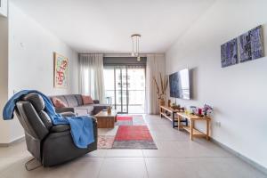 uma sala de estar com um sofá e uma mesa em Achziv Beach Haven 3BR Apartment by Sea N' Rent em Nahariya