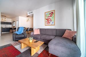 uma sala de estar com um sofá e uma mesa em Achziv Beach Haven 3BR Apartment by Sea N' Rent em Nahariya