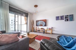 uma sala de estar com dois sofás e uma mesa em Achziv Beach Haven 3BR Apartment by Sea N' Rent em Nahariya