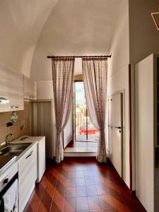 eine Küche mit einem Waschbecken und ein Fenster mit Vorhängen in der Unterkunft Locazione turistica La vecchia arcata in Noci