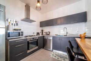 uma cozinha com utensílios de aço inoxidável e uma mesa de madeira em Achziv Beach Haven 3BR Apartment by Sea N' Rent em Nahariya