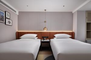 two beds in a small room with at Home2 Suites by Hilton Beijing West Station in Beijing