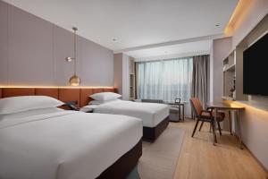 a hotel room with two beds and a flat screen tv at Home2 Suites by Hilton Beijing West Station in Beijing