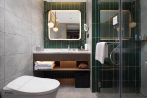a bathroom with a toilet and a sink and a mirror at Home2 Suites by Hilton Beijing West Station in Beijing