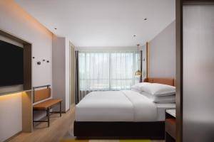 a hotel room with a bed and a television at Home2 Suites by Hilton Beijing West Station in Beijing