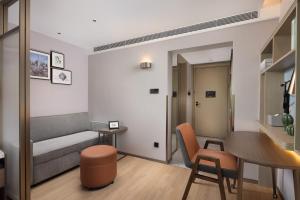 a living room with a couch and a table at Home2 Suites by Hilton Beijing West Station in Beijing