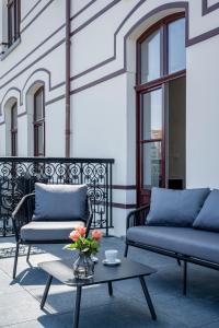 um pátio com dois sofás e uma mesa com flores em Hotel des Brasseurs em De Haan