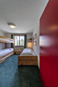 - une chambre avec 2 lits superposés et un mur rouge dans l'établissement Chesa Chatrigna - Celerina - apartment up to 5 people, à Celerina