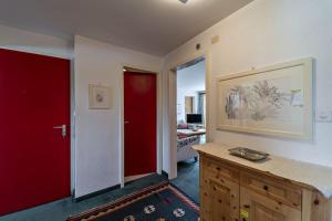 Cette chambre dispose d'une porte rouge et d'une porte rouge. dans l'établissement Chesa Chatrigna - Celerina - apartment up to 5 people, à Celerina