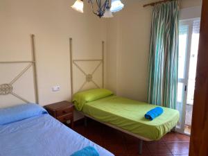 1 dormitorio con 2 camas individuales y ventana en Casa KIKO, LA CASA ESTA EN LA ANTILLA 200METROS PLAYA, en La Antilla