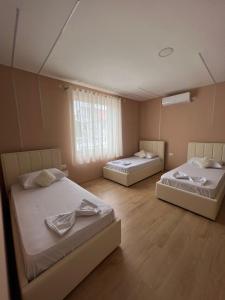 a room with two beds and a window at MIQT GUEST HOUSE in Shkodër +13 photos