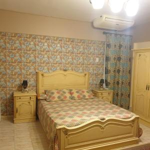 ein Schlafzimmer mit einem großen Bett und zwei Nachttischen in der Unterkunft شاليه راقي بمارسيليا بيتش 1 الساحل in Dawwār Muḩammad Abū Shunaynah