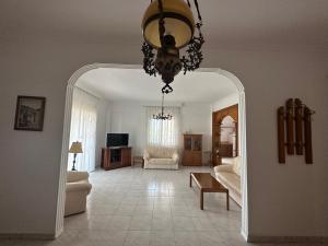 a living room with a chandelier and a room with a couch at Vrea Home in Nea Vrasna