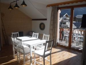 ein Esszimmer mit einem weißen Tisch und Stühlen auf dem Balkon in der Unterkunft Superbe appartement aux Orres 1800, six couchages in Les Orres