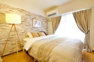 a bedroom with a bed and a brick wall at ウーブル博多504 in Sumiyoshi