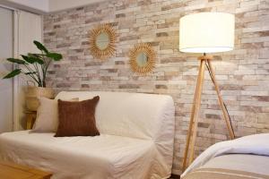 a living room with a white couch and a lamp at ウーブル博多504 in Sumiyoshi