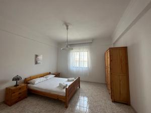 a bedroom with a bed and a wooden cabinet at Vrea Home in Nea Vrasna