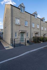 a large brick building on the side of a street at Comfortable townhouse in Tetbury, parking & garden in Tetbury
