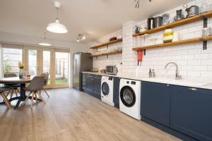 a kitchen with two washing machines and a table at Comfortable townhouse in Tetbury, parking & garden in Tetbury