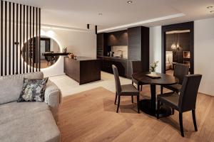 uma sala de estar com um sofá, uma mesa e uma cozinha em Schenna Chalet - Apt Stefan em Scena