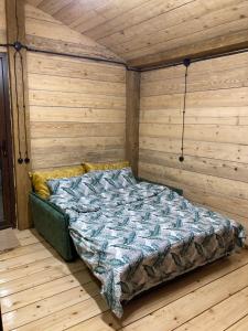Ce lit se trouve dans un dortoir doté d'un mur en bois. dans l'établissement MESTIA COTTAGE TiME, à Mestia
