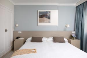 een slaapkamer met een groot wit bed met 2 kussens bij Prestige Mar y Sol in Roses