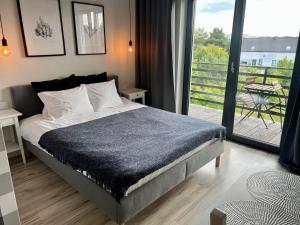 a bedroom with a bed and a balcony at WSCHODY I ZACHODY in Jastrzębia Góra