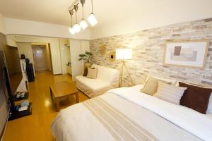 a bedroom with a bed and a living room at ウーブル博多504 in Sumiyoshi