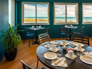 La Villa Saint Jean في لي سابلِ دولونْ: طاولة في مطعم مطل على المحيط