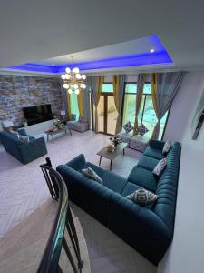 a living room with blue couches and a fireplace at Rose Beach Villas in Durat  Alarous