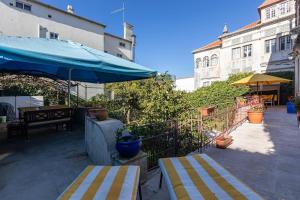 um pátio com 2 cadeiras e um guarda-sol azul em skyaccommodations Studio 3+ kitchen and double bed em Coimbra