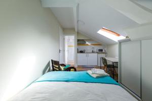 een kleine slaapkamer met een bed en een keuken bij skyaccommodations Studio 3+ kitchen and double bed in Coimbra