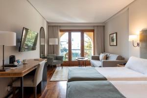 une chambre d'hôtel avec deux lits et un bureau dans l'établissement Parador de Ronda, à Ronda