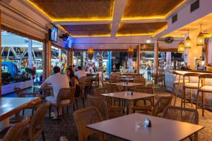 people sitting at tables in a restaurant at Blue Harbour Boutique in Ayia Napa