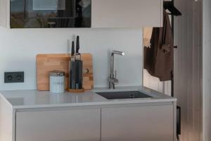 a kitchen counter with a sink and a knife block at Exclusive off-grid tiny home at the beach - Kenshó 